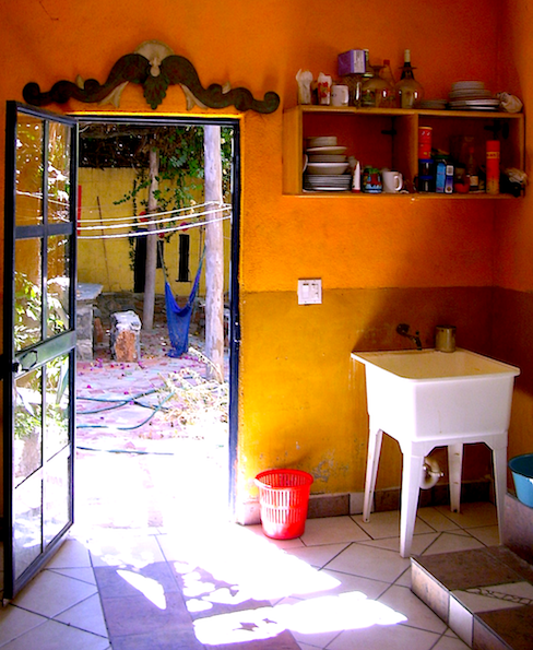kitchen of La Casa Azul, door open to the patio, orange walls