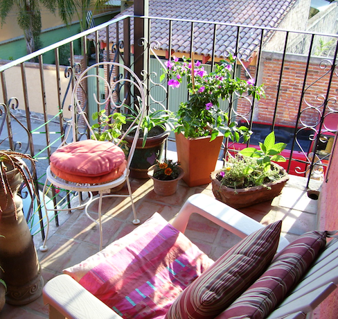 my Ajijic balcony with the chair and pots of flowers, including the terra cotta I mention with the bougainvillea