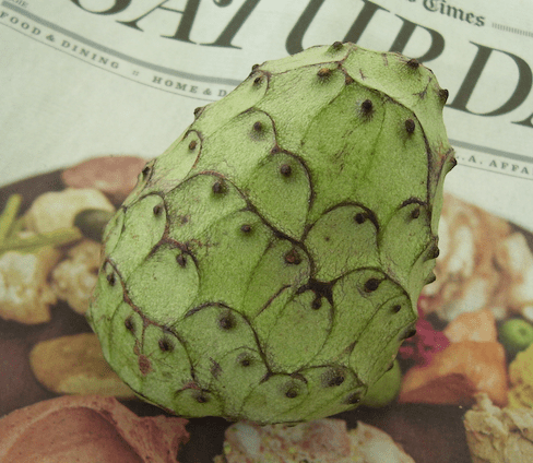 cherimoya sitting on the Saturday section of the L.A.Times