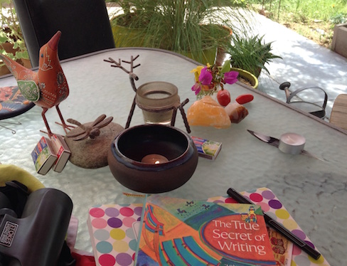 book, notebook, binoculars, candles, altar things on patio table
